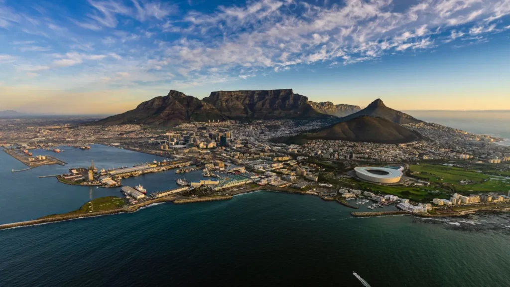 A panoramic aerial view of Cape Town, South Africa, with Table Mountain and the cityscape, highlighting a popular add-on destination for visitors to the 2025 International Pairs World Final.