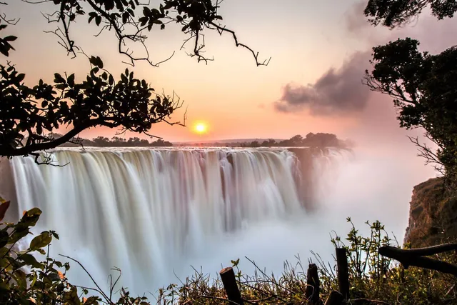 The majestic Victoria Falls at sunset, showcasing one of the breathtaking add-on holiday packages available for attendees of the 2025 International Pairs World Final in South Africa.